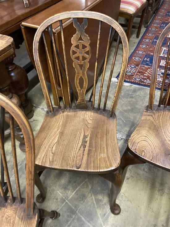 A set of eight early 20th century elm and beech Windsor wheelback dining chairs, with crinoline stretchers (two with arms)